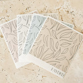 Set of three patterned dishcloths on a textured stone kitchen bench with 'FAYDED' branding.