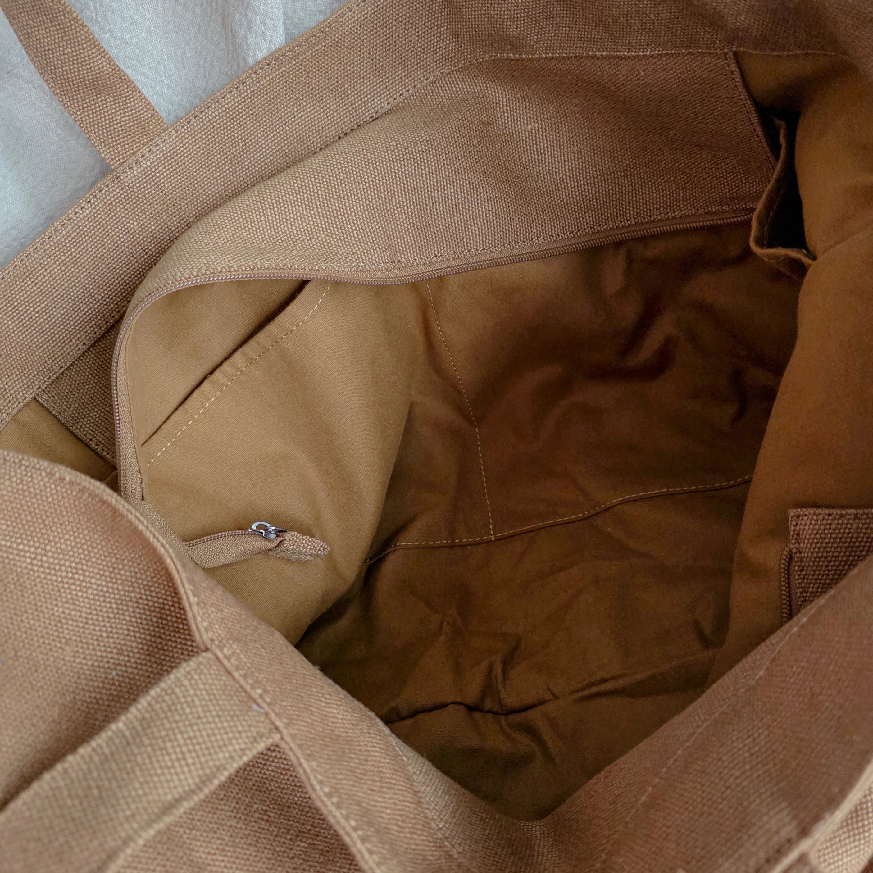 Close-up of a brown linen fabric bag with straps. 