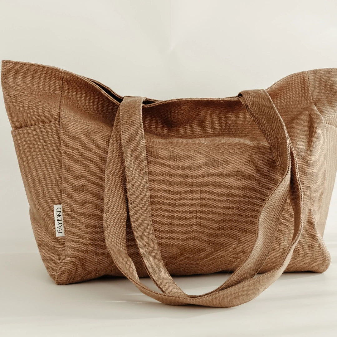Brown linen tote bag with visible fayded label on a light background