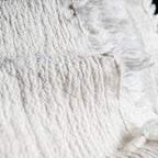 Close-up of textured white linen fabric with fringes