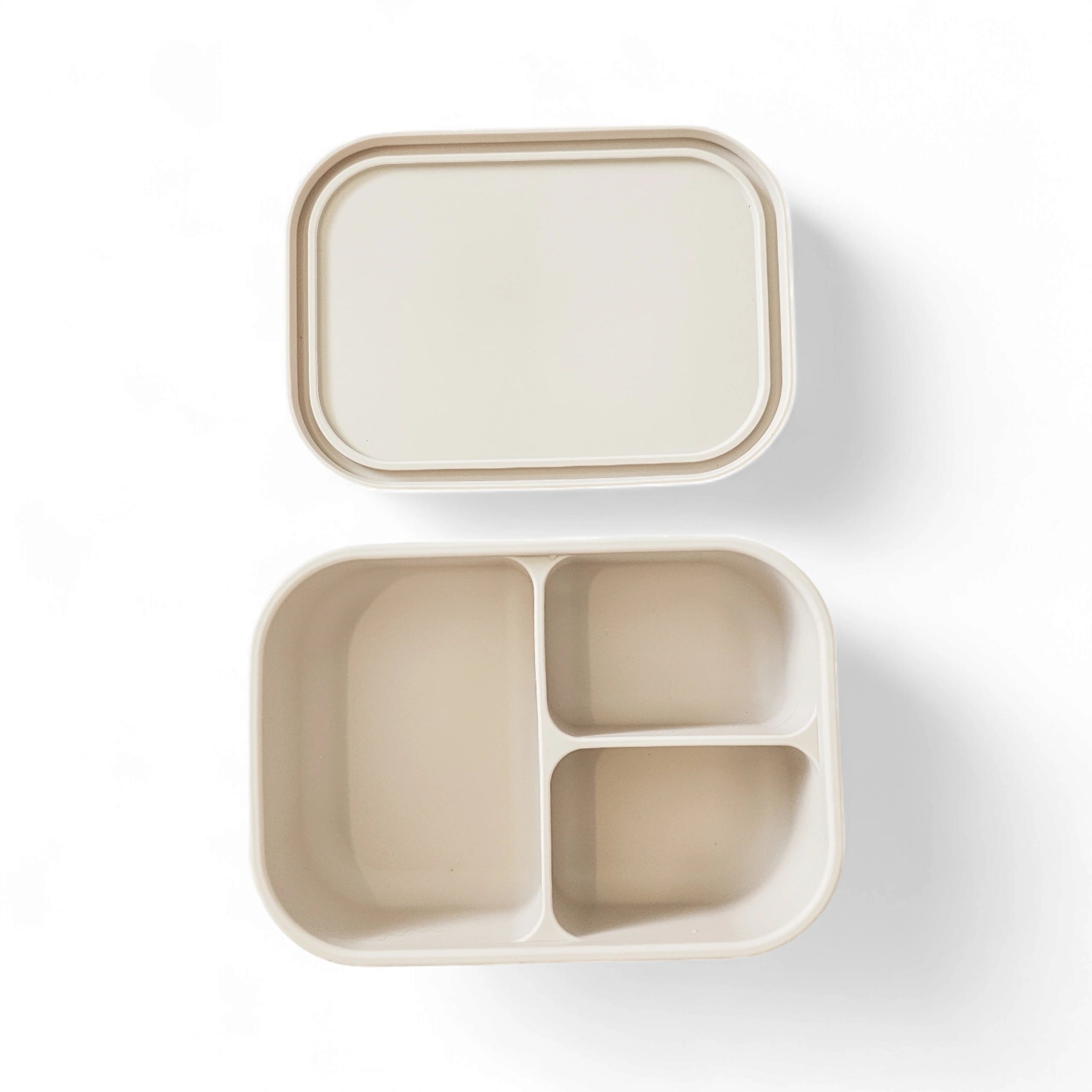 Beige compartmentalized bento box container with lid on a white background